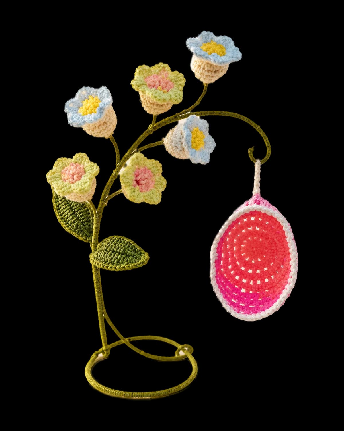 Handmade crochet bellflower stand with cream, pale blue and soft yellow flowers, green leaves and a pink swing