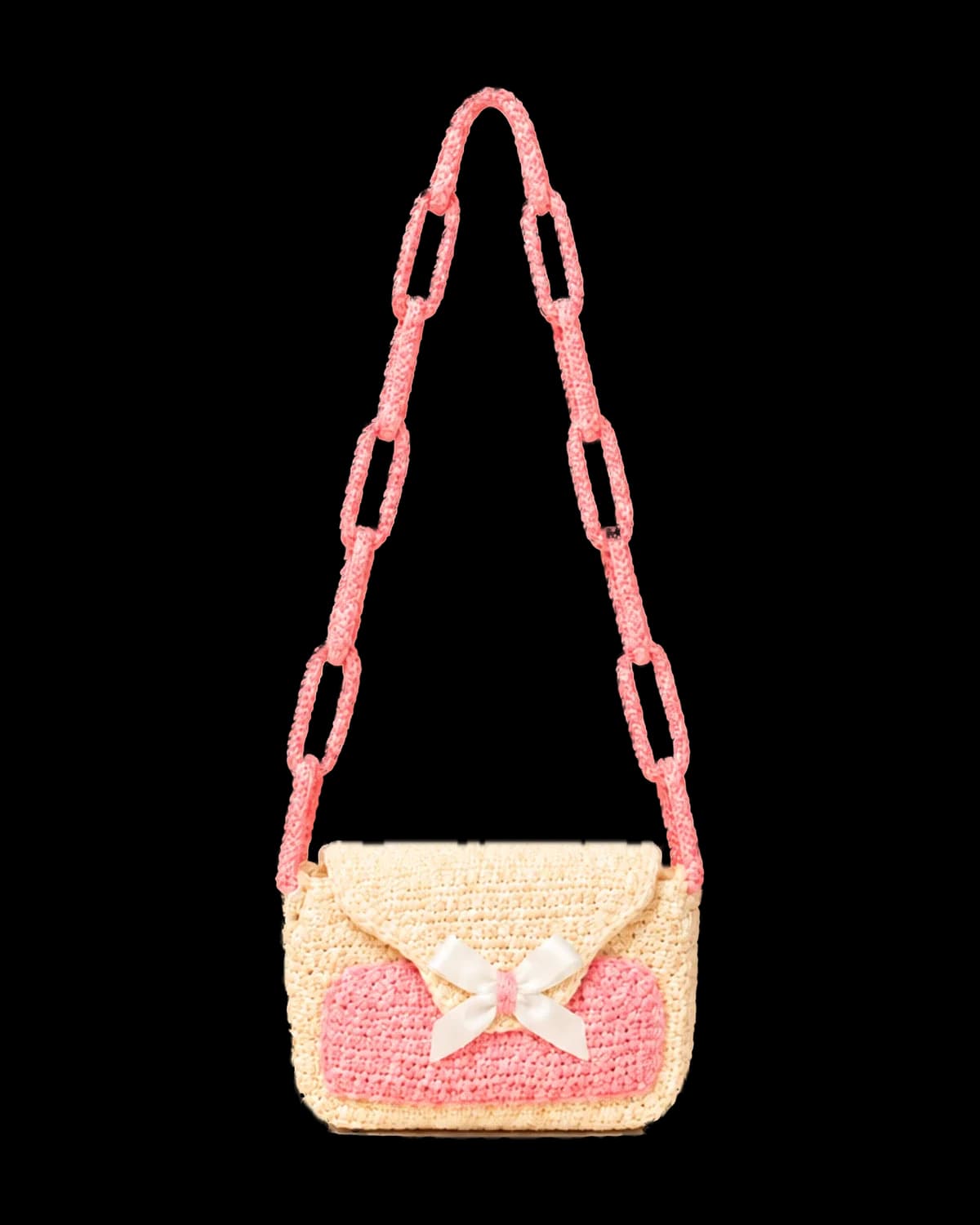 Cream crochet flap purse with a blush pink front panel, white satin bow and long pink crochet chain-link strap, front view on a cream background