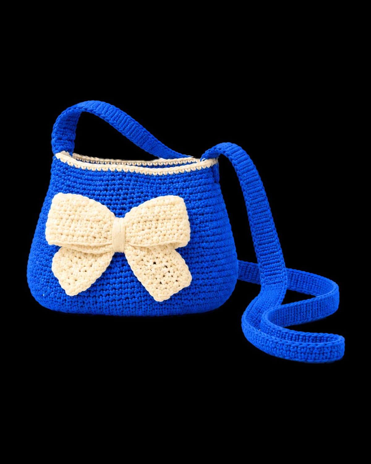 Royal-blue crochet bucket bag with a cream rim, a large cream crochet bow on the front and a long blue crochet strap