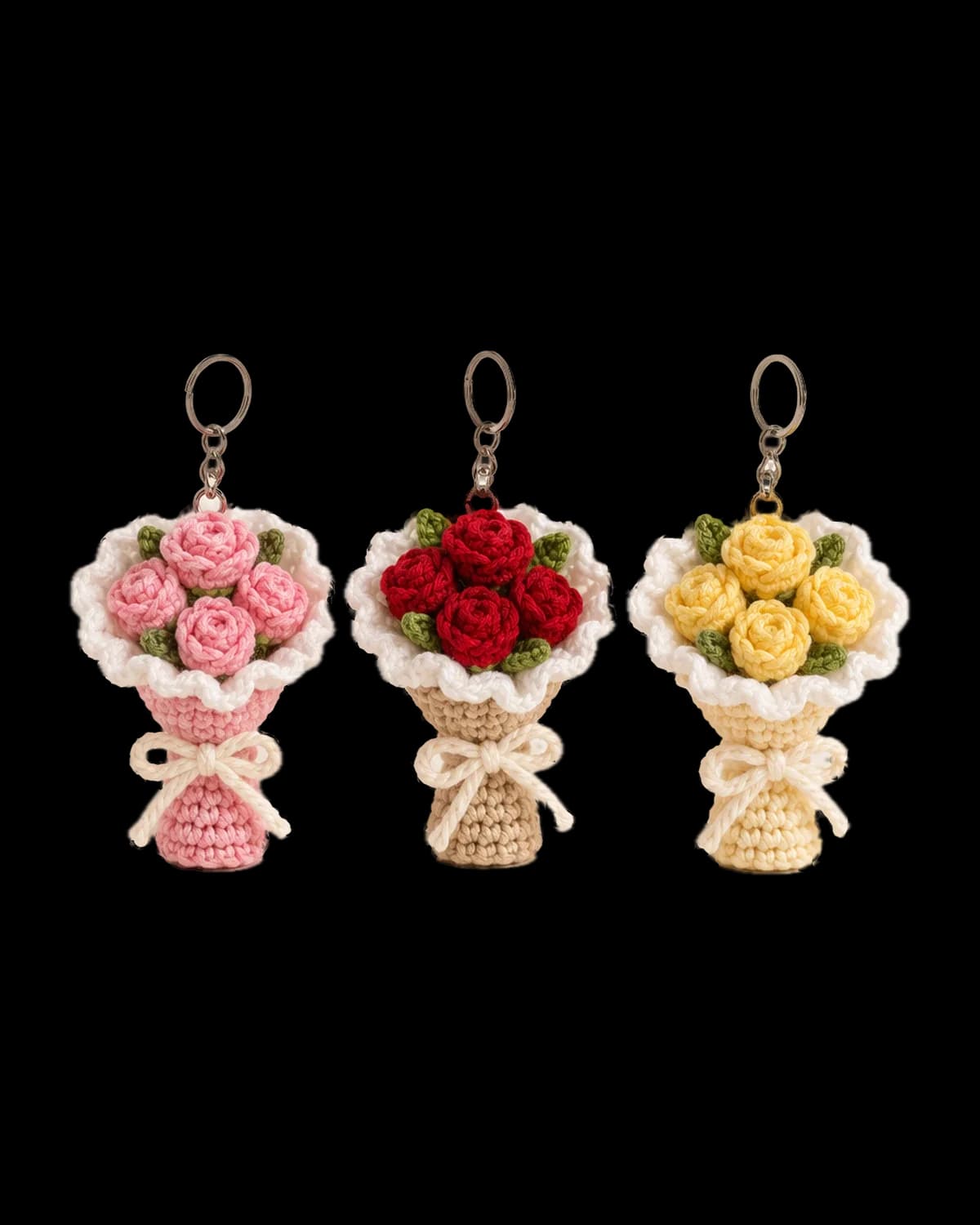 Three crochet mini bouquet keychains with pink, red and yellow roses, white ruffled wraps, cream bows and silver key rings