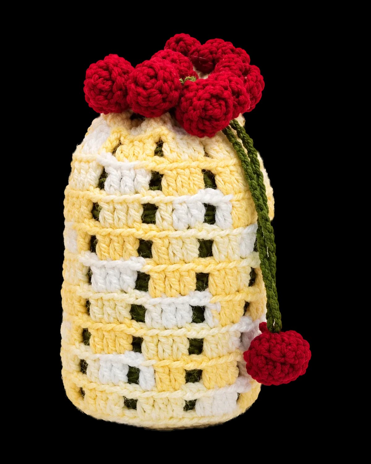 Handmade crochet drawstring potli in butter-yellow and white block stitch with deep-red rosebuds and a green cord