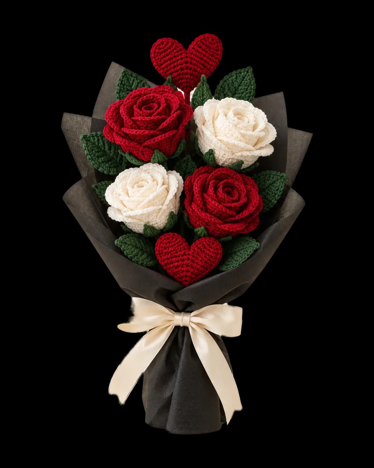 Crochet bouquet of two red and two white roses with green leaves and two red hearts, wrapped in black florist wrap with a cream satin bow