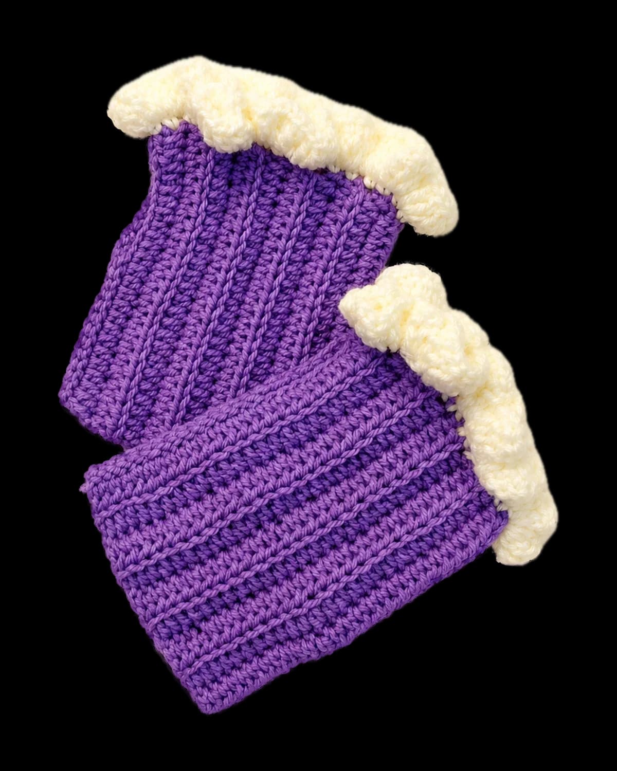 Purple ribbed crochet fingerless gloves with cream ruffle cuffs, laid flat as a pair